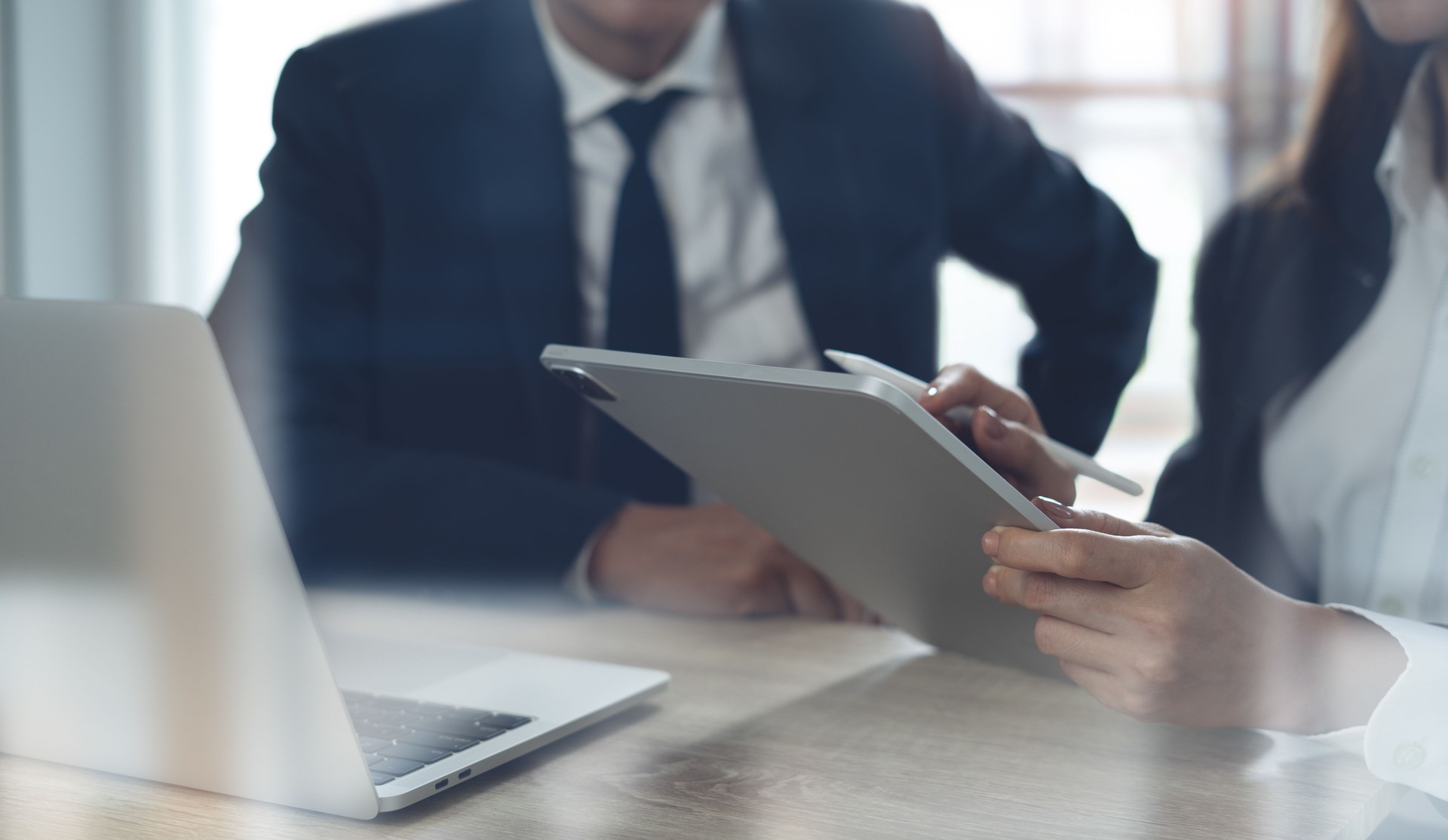 Two business person using digital tablet and having a discussion in office. Asian business team, colleague working together. Partnership, Teamwork and collaboration, corporate business, close up